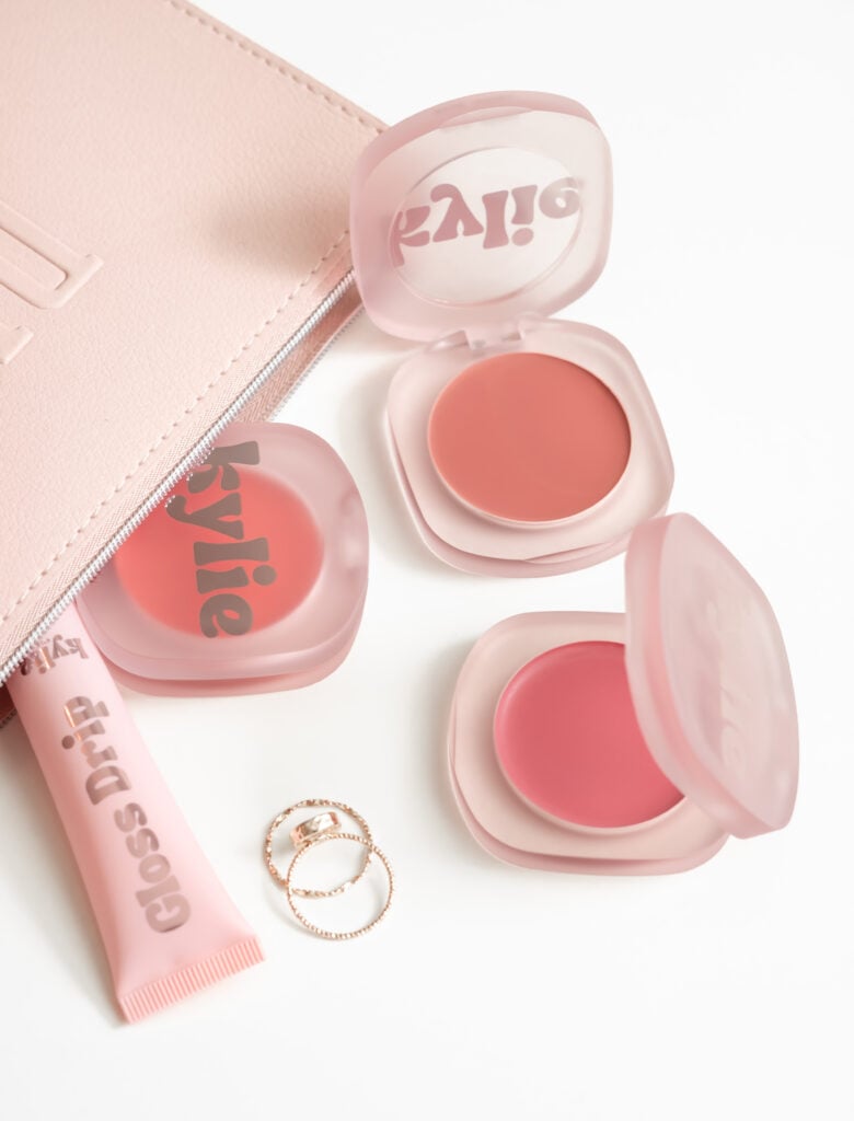 Three cream blush compacts in pink packaging with coral and rose shades displayed